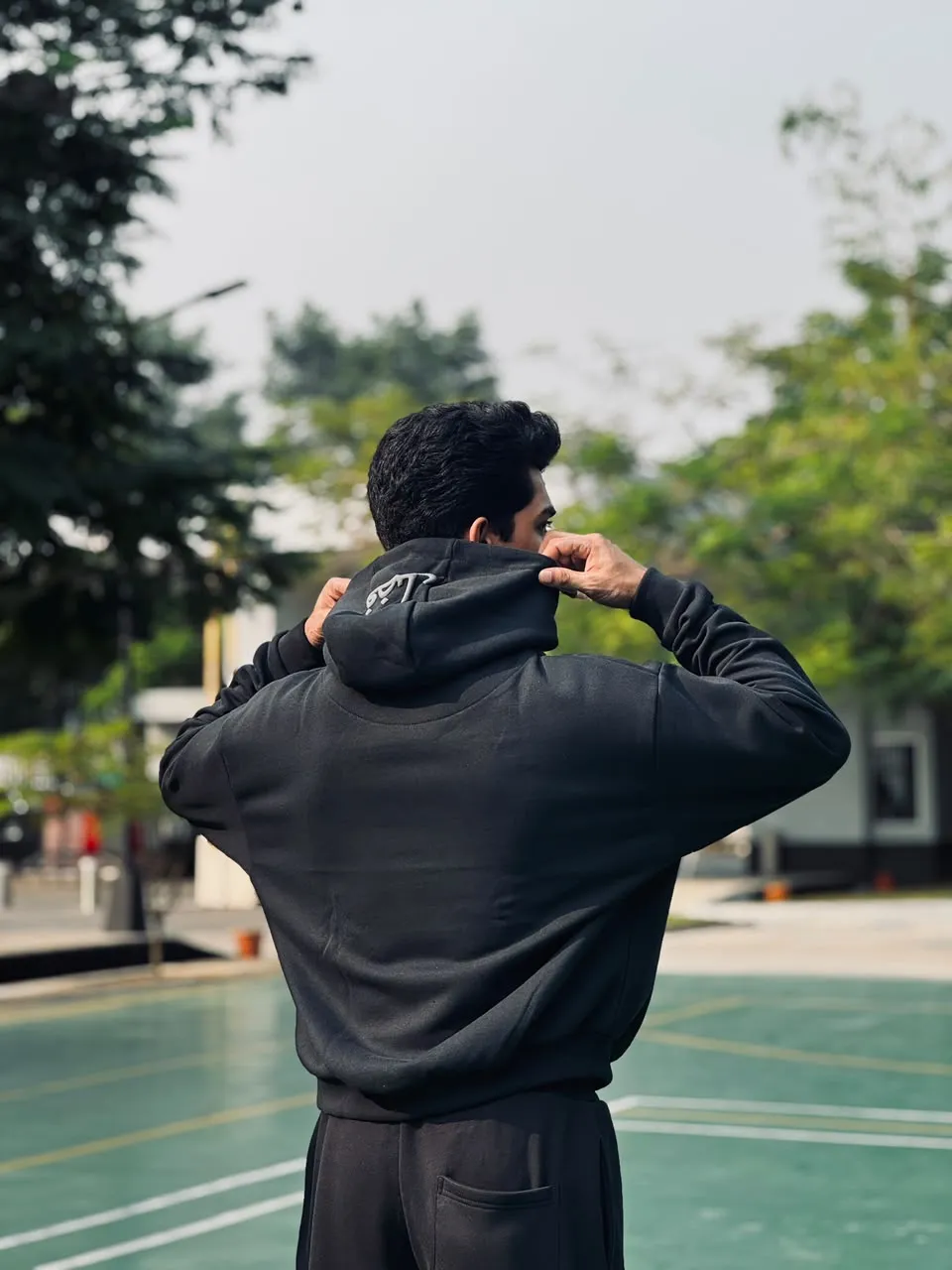 Back of the black FAZAL hoodie, showing the embroidered فضل mark on the hood