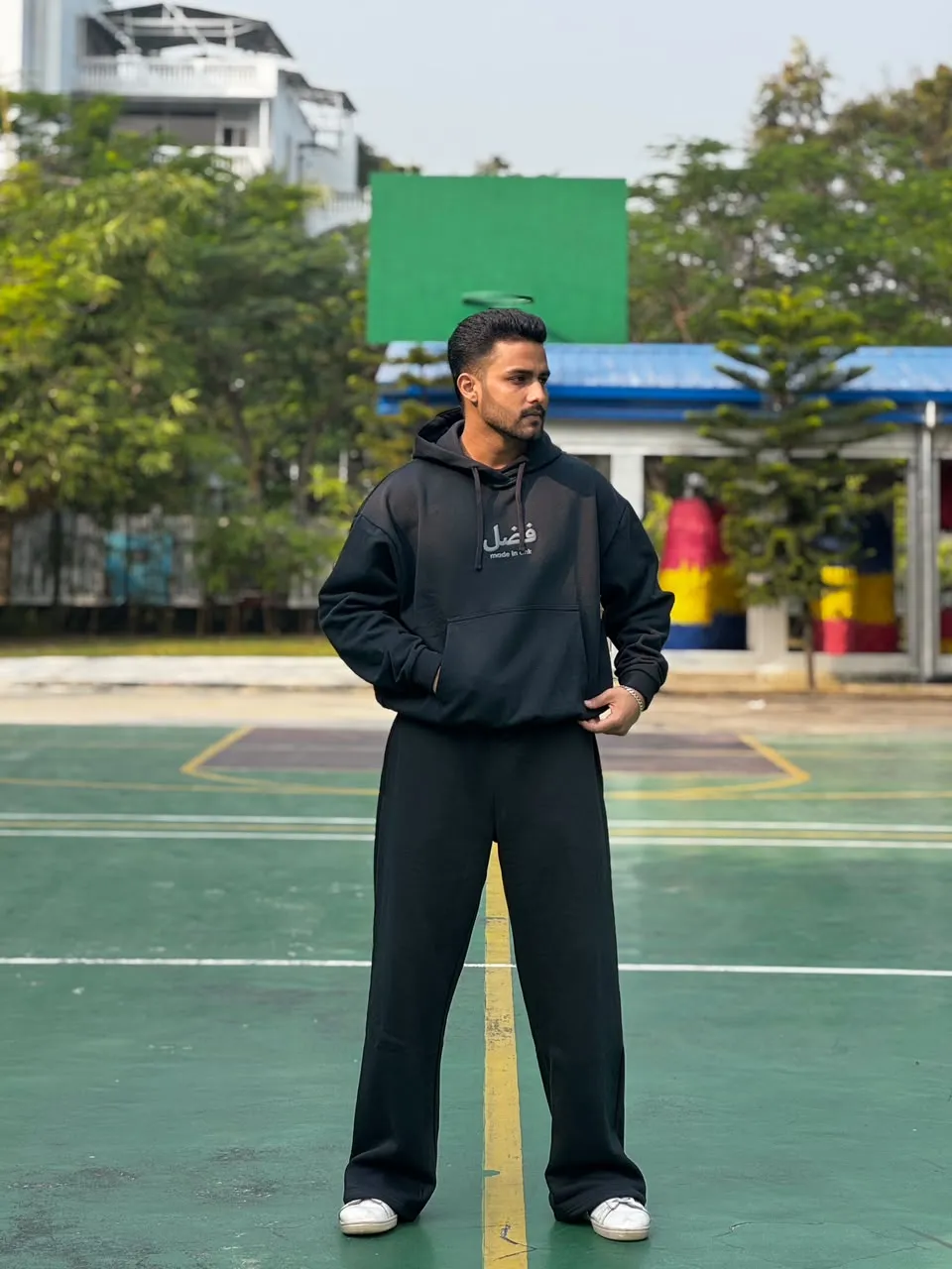 Model in the Obsidian black FAZAL hoodie set on an outdoor court